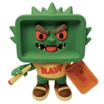 Toy green monster figure with a square, boxy head, wearing a RAW shirt, holding a yellow crayon and an orange tray.