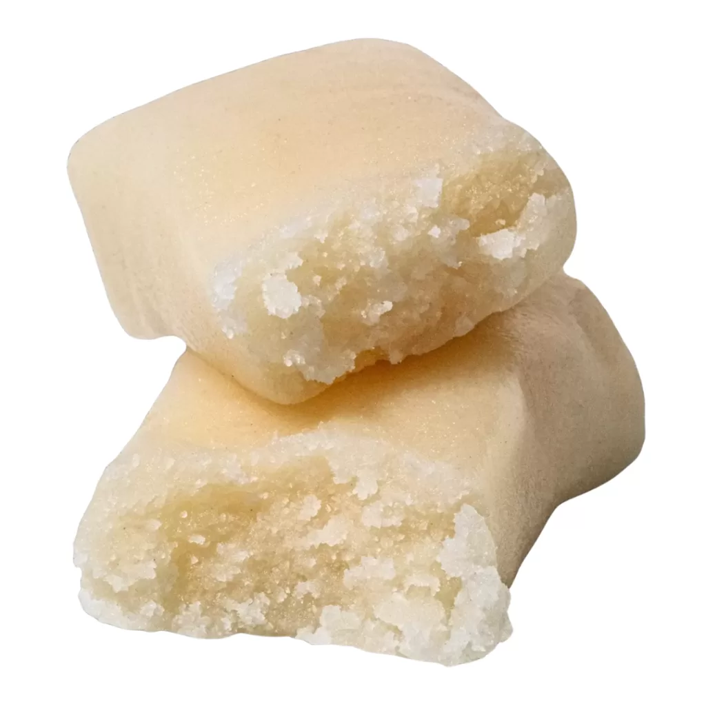 Two light beige, rectangular chunks with a rough, crumbly white crystalline interior showing at the broken ends, stack on top of each other