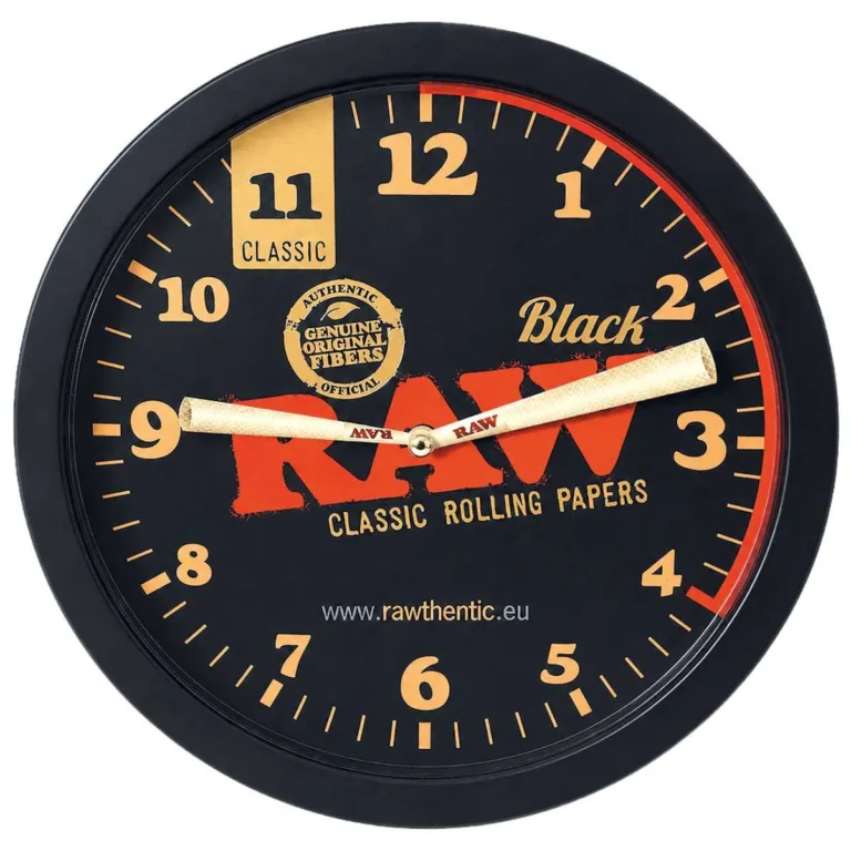Round wall clock with RAW branding and orange numerals on a black face; beige hands and promotional text.