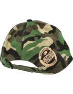 Back view of a camouflage baseball cap with an adjustable plastic strap and round beige patch reading AUTHENTIC GENUINE ORIGINAL FABRIC.