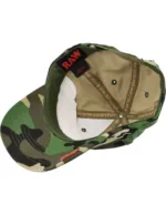 Camouflage baseball cap viewed from above, showing interior beige lining and green fabric with RAW tag.